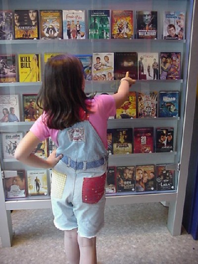 M&auml;dchen im Videoladen bei der Auswahl