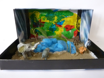 Der Hintergrund ist bunt. Mein Objekt stellt eine Oase da. Die Bl�tter symbolisieren die B�ume, das Gr�n. Der Sand ist Meersand. Das Wasser habe ich aus blaugef�rbter Wolle gemacht.